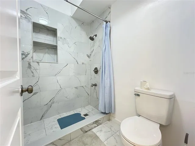 a white toilet sitting next to a bathroom