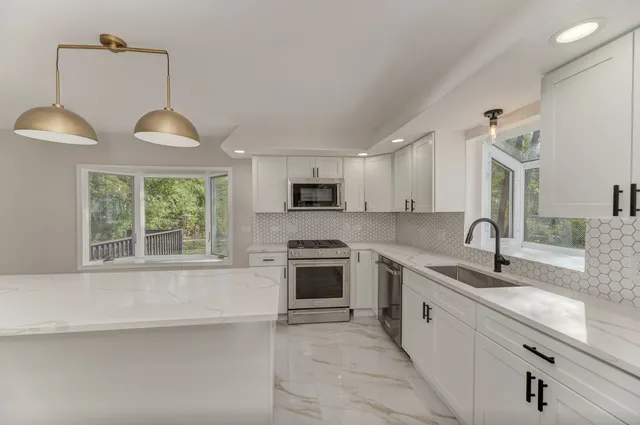 a kitchen with granite countertop a stove a sink and a microwave