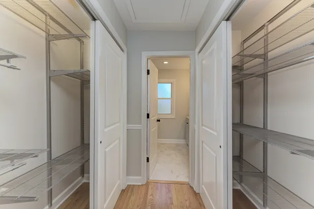 a view of a hallway with wooden floor and closet