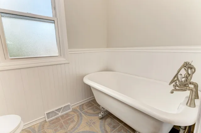 a bath tub sitting next to a white sink and a toilet