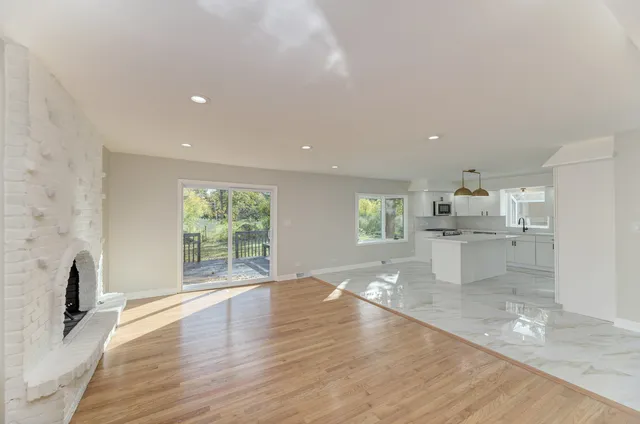 a view of empty room with wooden floor and fireplace