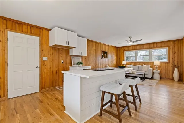 a bathroom with a granite countertop sink a toilet a large mirror a bathtub and next to a window
