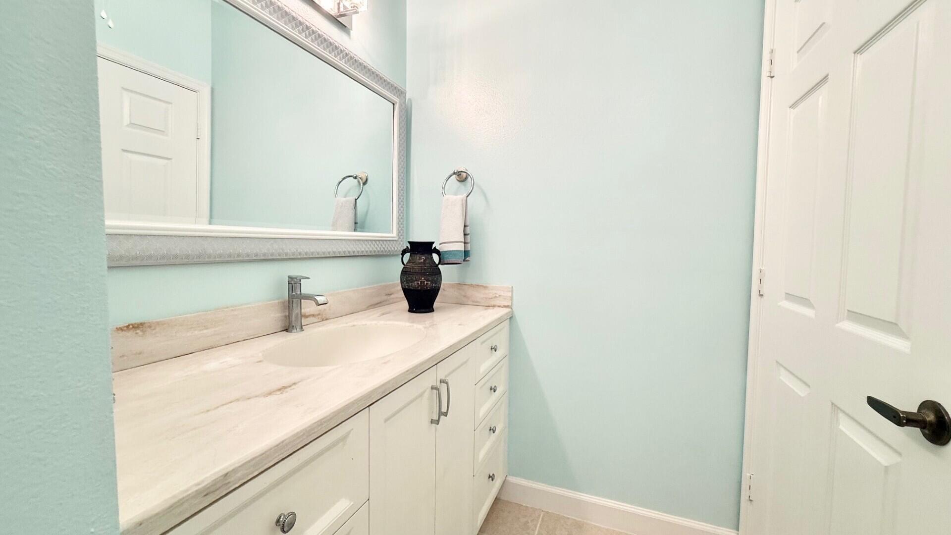 9905 Galleon Drive West Palm Beach, FL 33411 - Photo 11 of 16 a bathroom with a sink and a mirror
