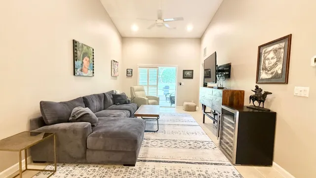 a living room with furniture a large window and flat screen tv
