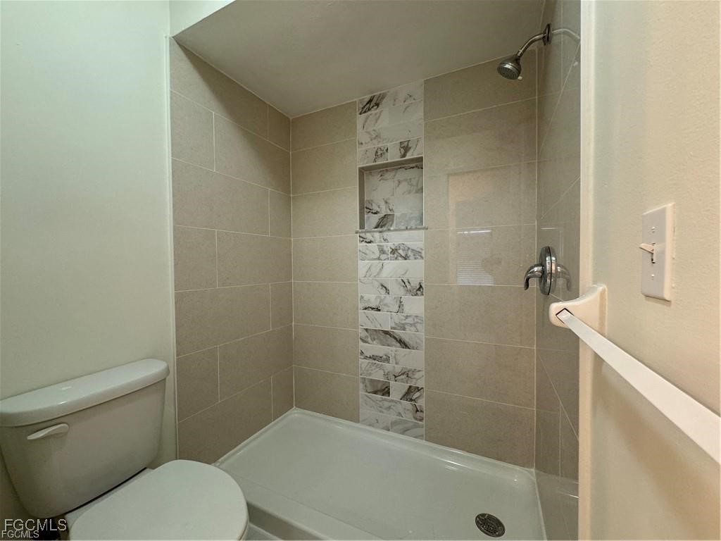 645 Homestead Road South Lehigh Acres, FL 33974 - Photo 11 of 17 a bathroom with a toilet and shower