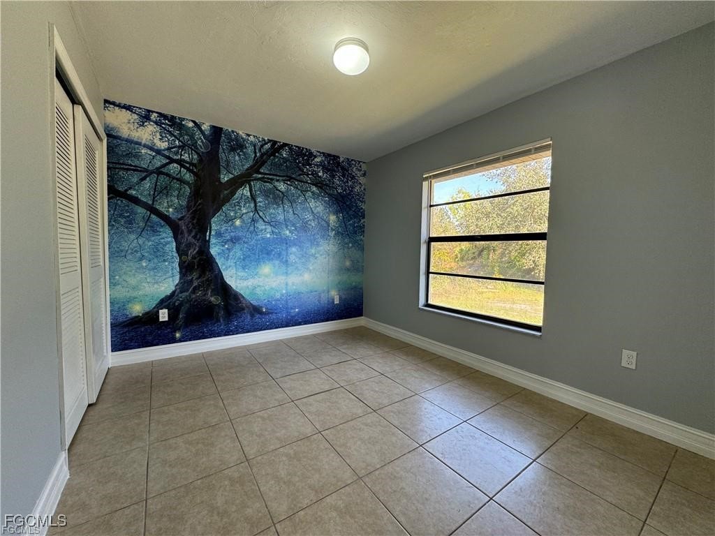 645 Homestead Road South Lehigh Acres, FL 33974 - Photo 14 of 17 a view of an empty room with wooden floor and a window