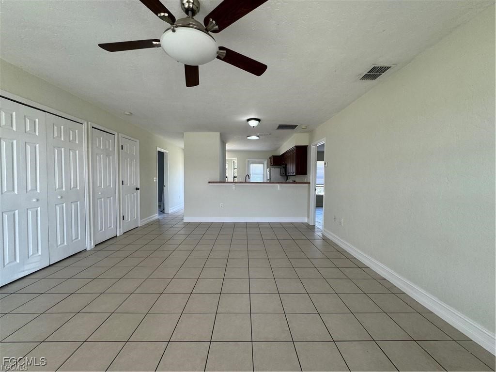 645 Homestead Road South Lehigh Acres, FL 33974 - Photo 3 of 17 an empty room with ceiling fan and window