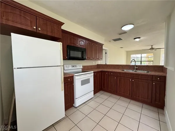 a kitchen with a sink a stove top oven and refrigerator