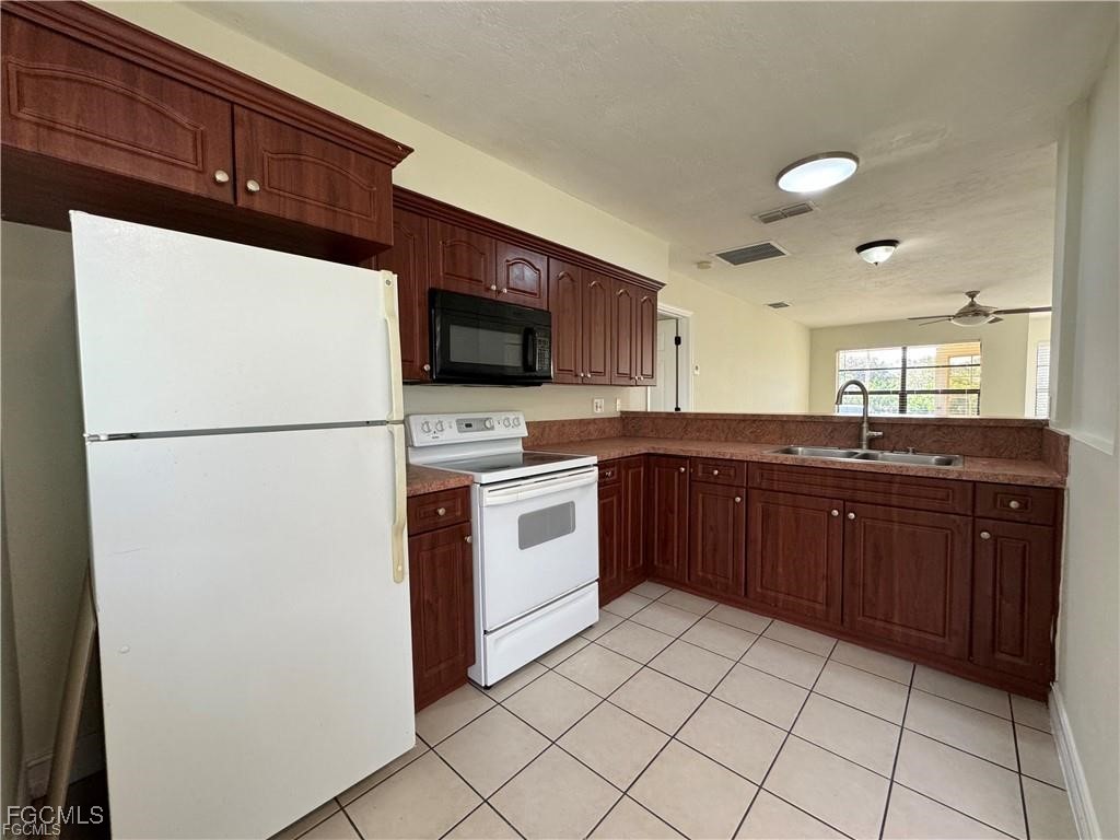 645 Homestead Road South Lehigh Acres, FL 33974 - Photo 6 of 17 a kitchen with a sink a stove top oven and refrigerator