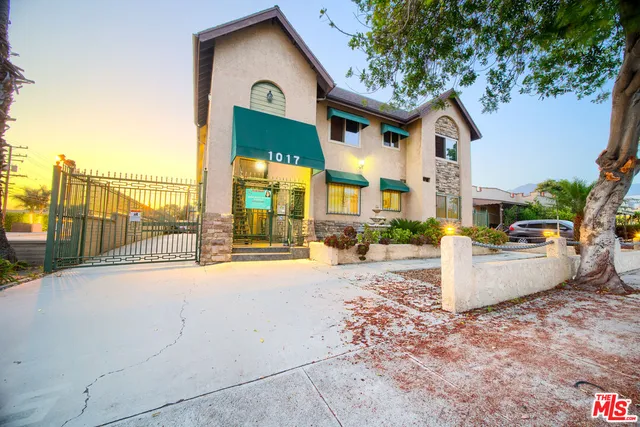 a front view of a house with a yard and potted plants