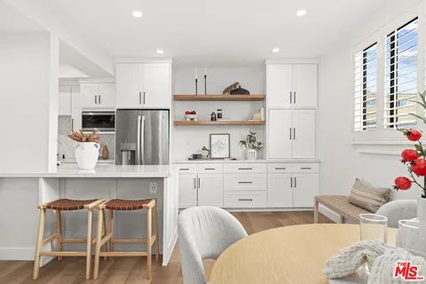 a kitchen with white cabinets and stainless steel appliances