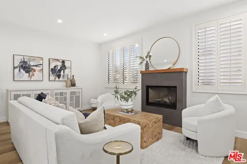 a living room with furniture a fireplace and a window