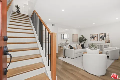 a living room with white walls and a floor to ceiling window