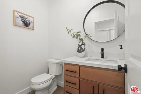 a bathroom with a sink mirror and toilet
