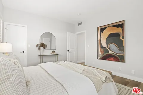 a bedroom with a bed and a painting on the wall