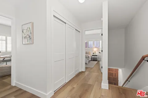 a view of a hallway with bathroom and wooden floor