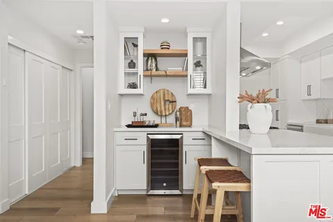 a kitchen with kitchen island granite countertop a sink cabinets and stainless steel appliances