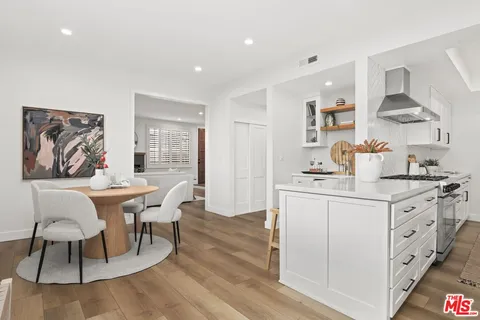 a kitchen with stainless steel appliances granite countertop a white cabinets and wooden floor