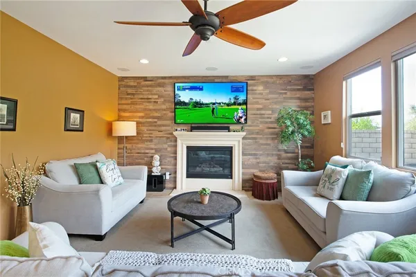 a living room with furniture and a large window with kitchen view