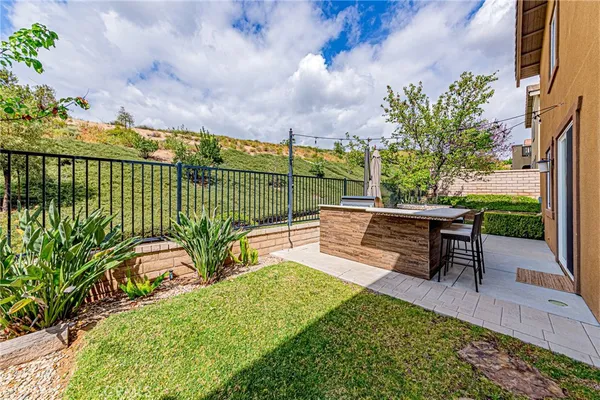 a view of house with a yard and potted plants