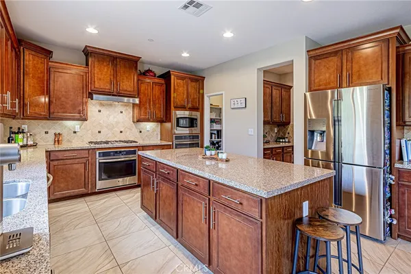 a kitchen with stainless steel appliances granite countertop a stove a sink and a microwave