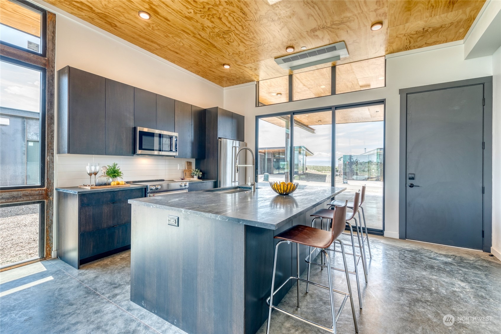 228 (lot 32) Nw Rattlesnake Point Road Quincy, WA 98848 - Photo 7 of 38 a kitchen with stainless steel appliances granite countertop a stove a refrigerator a oven a sink with island chairs and wooden cabinets