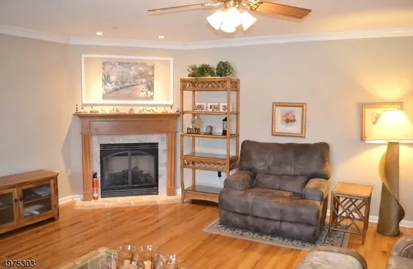an empty room with wooden floor and a ceiling fan