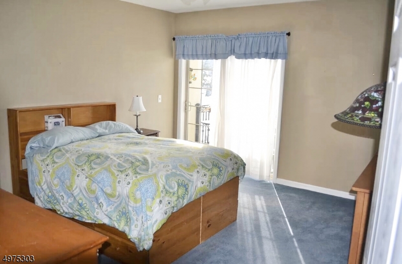16 Main Street, Unit 1 Sparta, NJ 07871 - Photo 18 of 28 a bed sitting in a bedroom next to a window