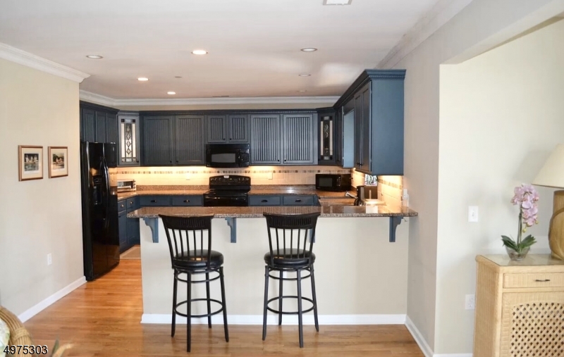 16 Main Street, Unit 1 Sparta, NJ 07871 - Photo 5 of 28 a kitchen with stainless steel appliances a dining table chairs and wooden floor