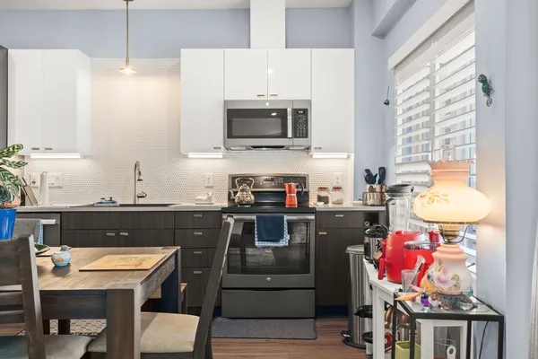 a kitchen with stainless steel appliances granite countertop a stove a sink and a microwave