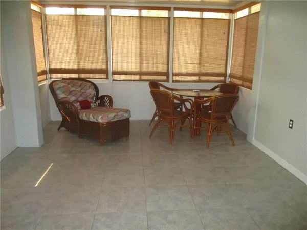 a dining room with furniture and large windows