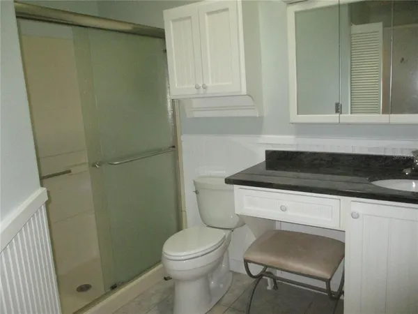 a bathroom with a granite countertop sink toilet and shower