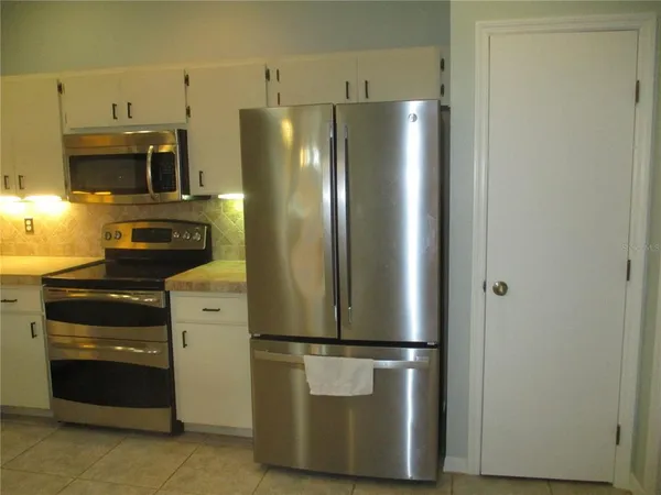 a metallic refrigerator freezer sitting in a kitchen
