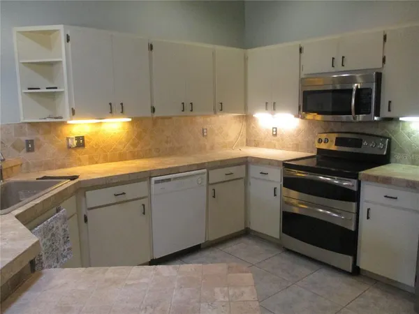 a kitchen with stainless steel appliances granite countertop a sink and a stove