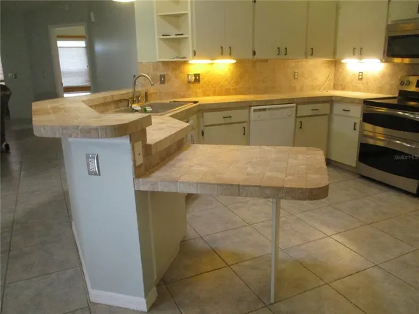 a kitchen with a sink a stove cabinets and dining table