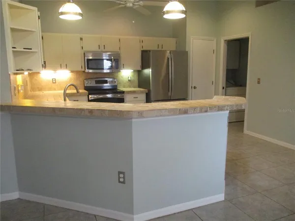 a kitchen with kitchen island granite countertop cabinets and stainless steel appliances