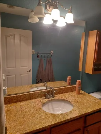 a bathroom with a granite countertop sink and a mirror
