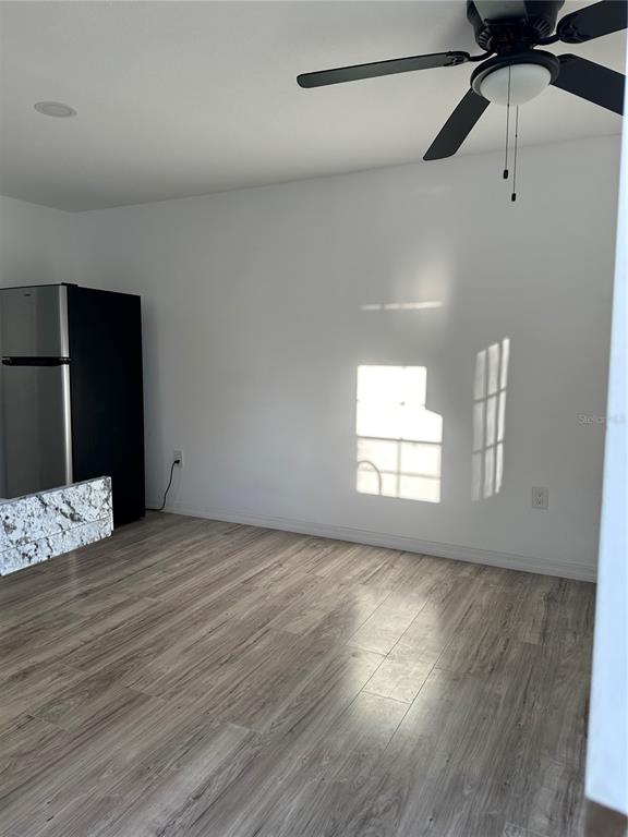 11382 Mahopac Road Weeki Wachee, FL 34614 - Photo 29 of 35 an empty room with wooden floor fan and windows