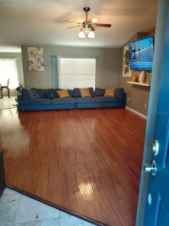 a living room with hard wood floors and a kitchen view