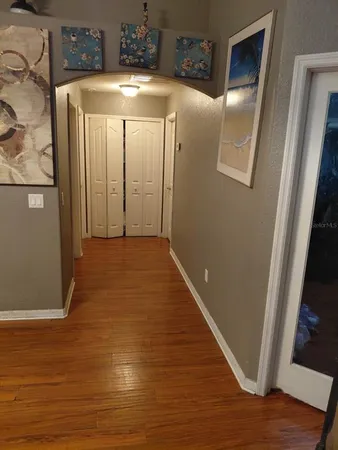a view of a hallway with wooden floor