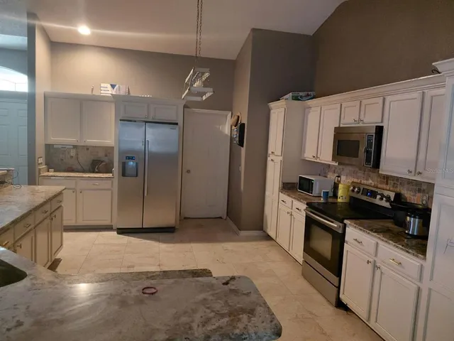 a kitchen with granite countertop a refrigerator and a sink