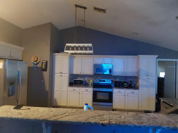 a kitchen with stainless steel appliances granite countertop a stove a refrigerator and a sink