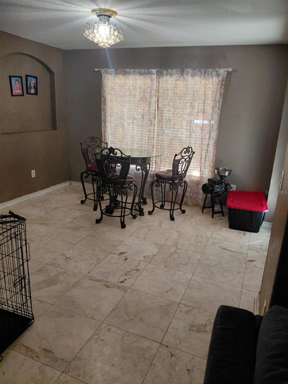11382 Mahopac Road Weeki Wachee, FL 34614 - Photo 9 of 35 a living room with furniture and a chandelier
