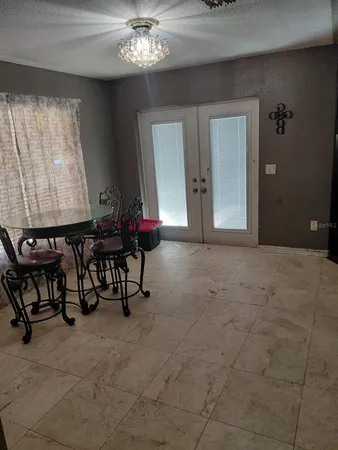 a view of an empty room with furniture and a chandelier