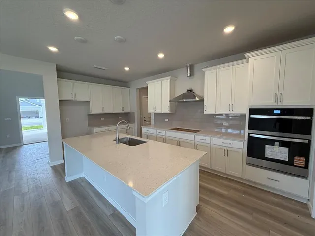 a large kitchen with stainless steel appliances granite countertop a stove a sink and a refrigerator