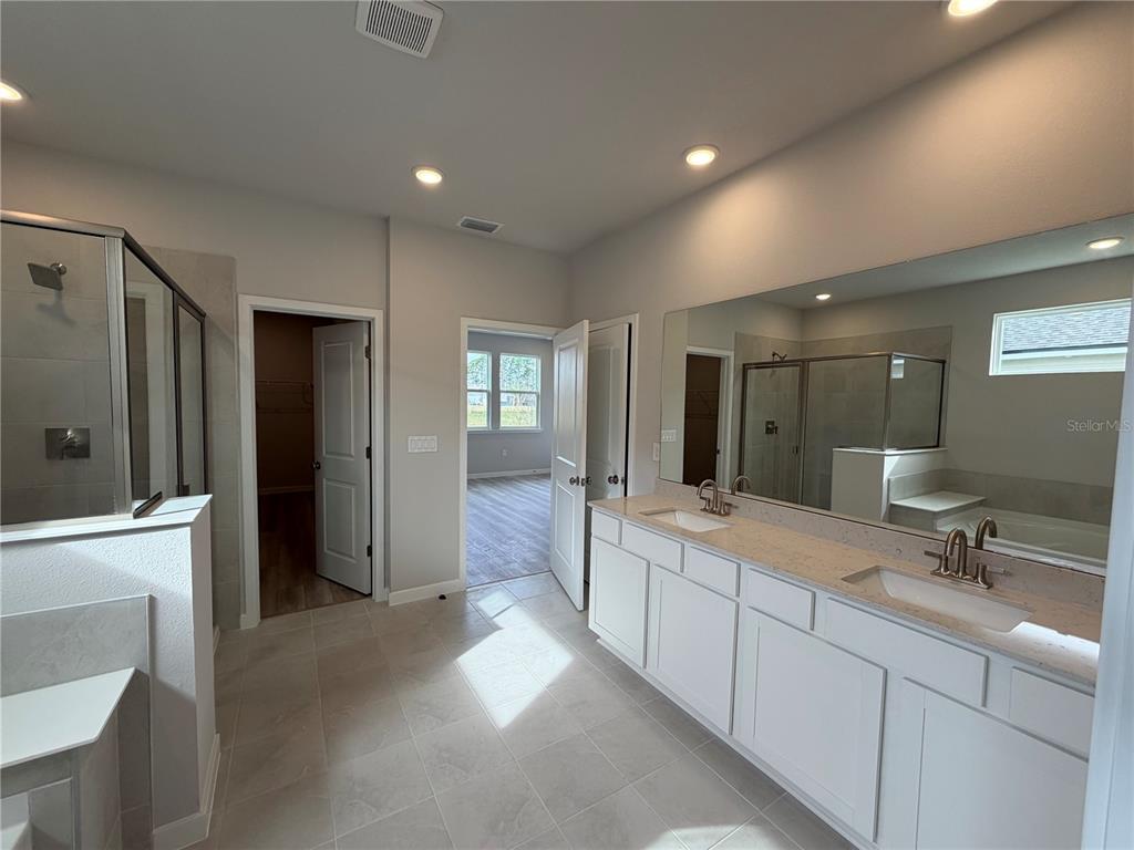 57 Pegasus Road Flagler Beach, FL 32136 - Photo 22 of 45 a spacious bathroom with a double vanity sink a large mirror and shower
