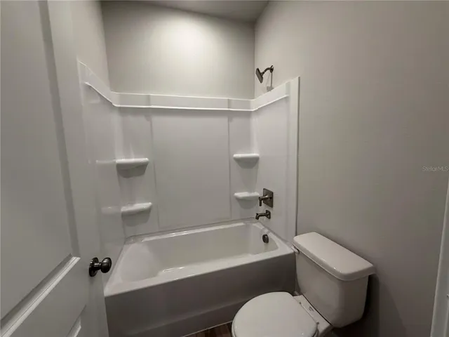a bathroom with a toilet and bathtub