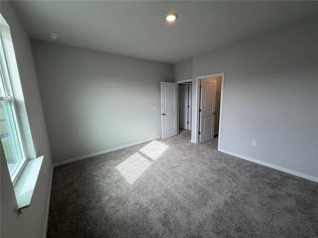 an empty room with windows and closet