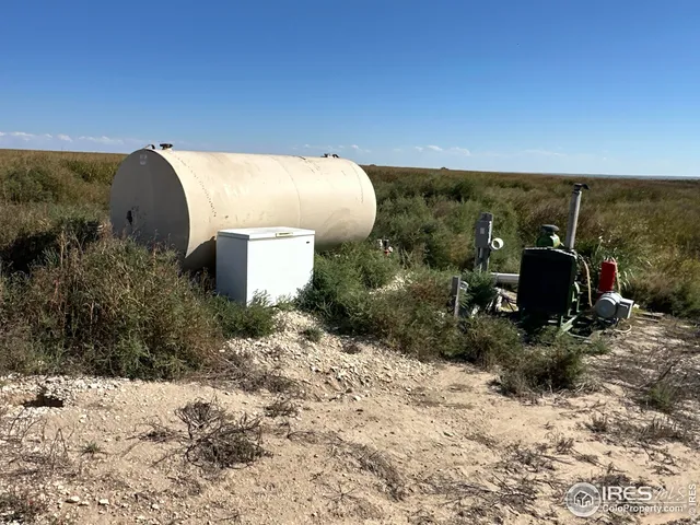 a view of a dry yard with wooden fence