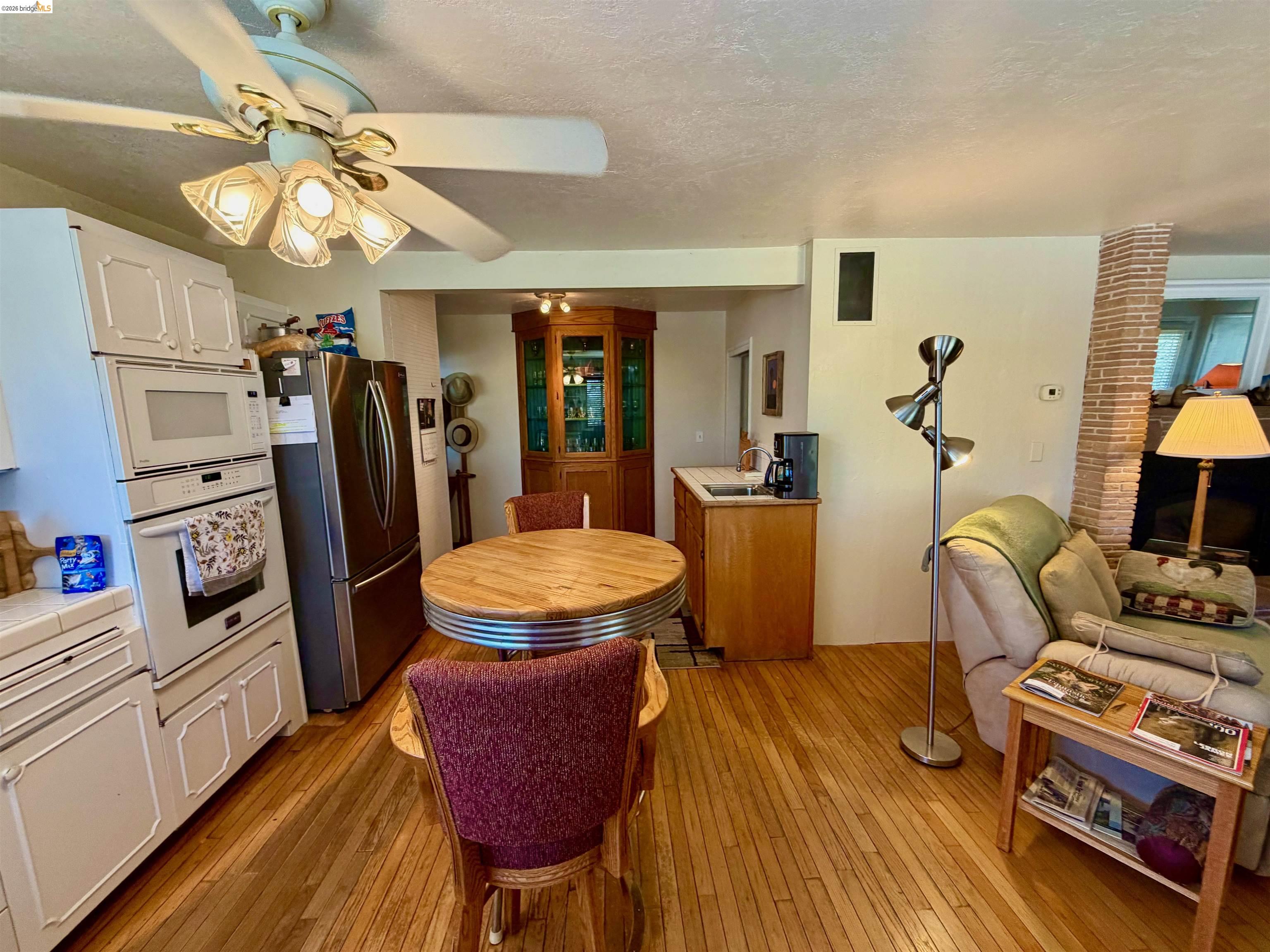 18195 Wards Ferry Road Sonora, CA 95370 - Photo 65 of 67 Hardwood flooring throughout featuring a kitchen with white cabinetry and stainless steel appliances